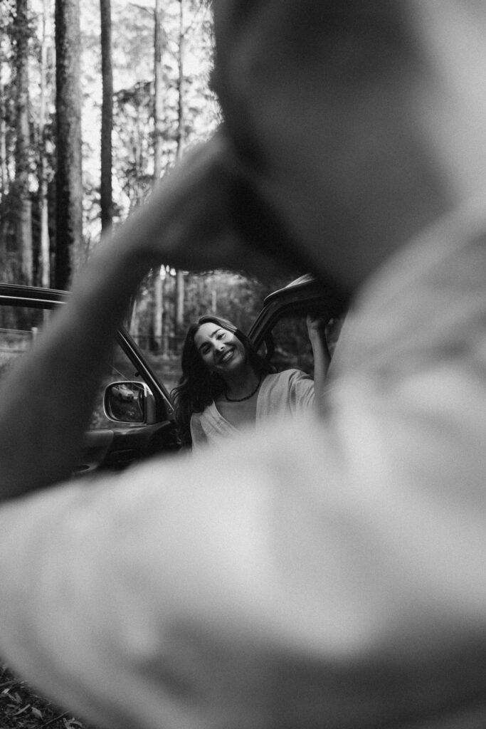 Candid cinematic couples photography in Maleny and Mapleton, Sunshine Coast. A joyful, nature-loving couple share a relaxed moment in the forest, captured in a warm, documentary style that reflects earthy van-life storytelling. Photographed by Nicci K, Sunshine Coast couples and elopement photographer.
