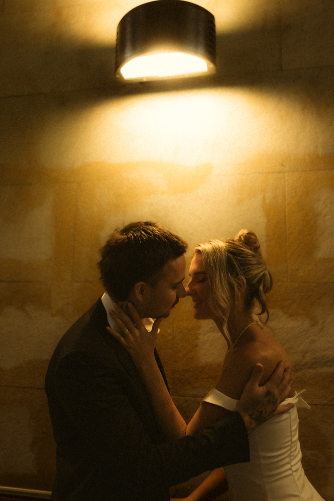 Close-up golden-lit shot of bride and groom's foreheads touching