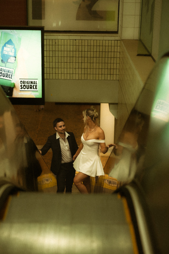 Couple on platform at central railway station brisbane holding hands after getting married