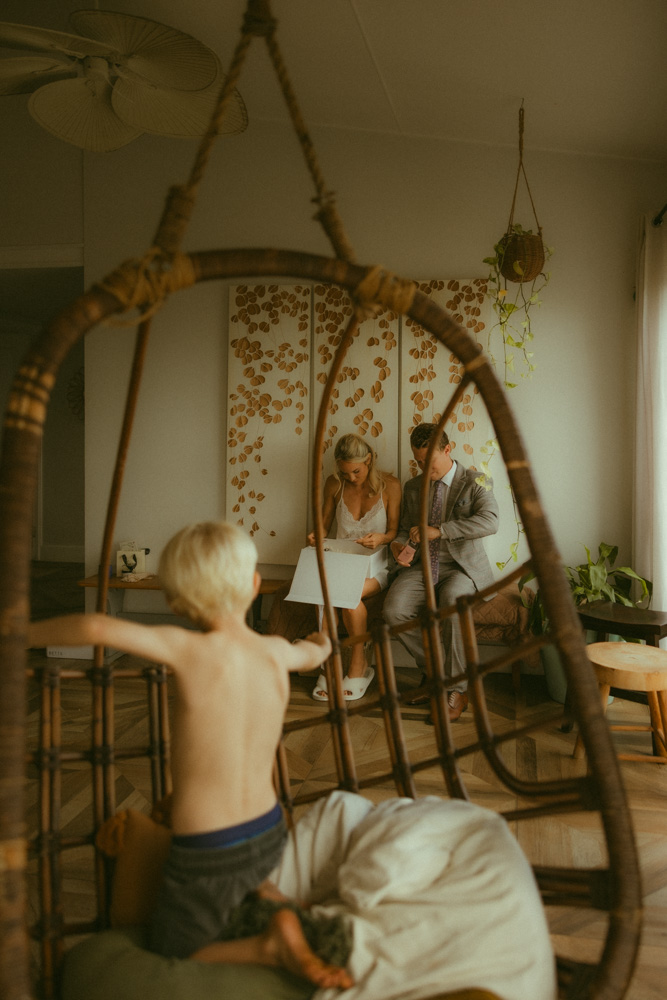 Bride receiving a bridal gift from her brother while her son watches from an egg chair