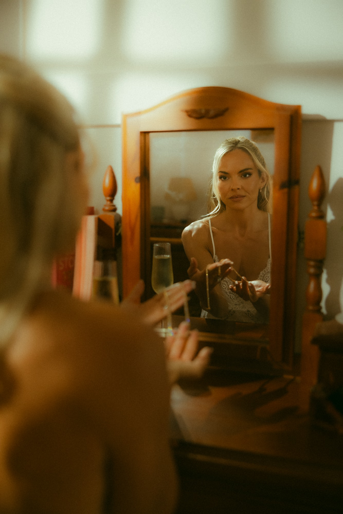 Bride looking into the mirror whilst getting ready for her sunshine coast hinterland elopement 