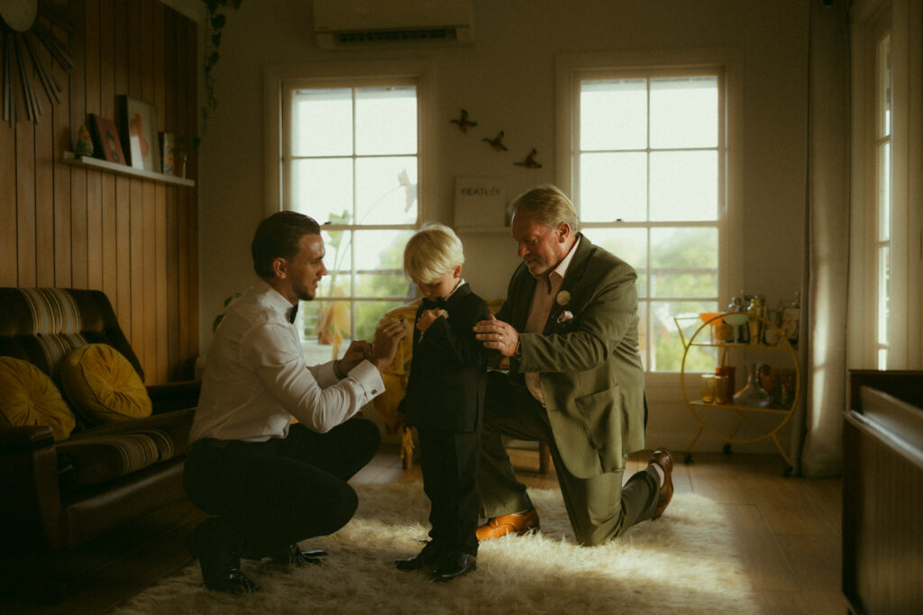 Groom, Grandfather and grooms son getting ready in a vintage style cabin