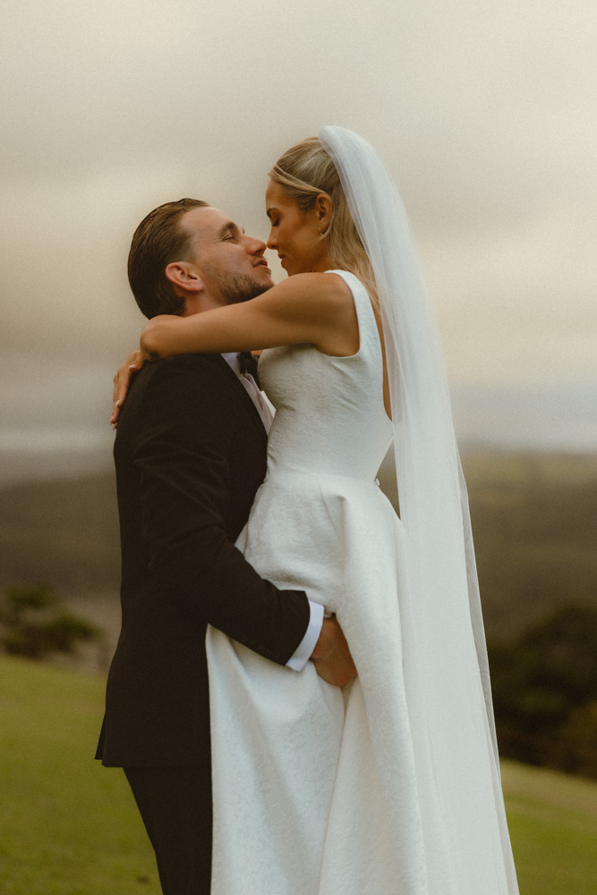 Groom lifting bride up and touching noses