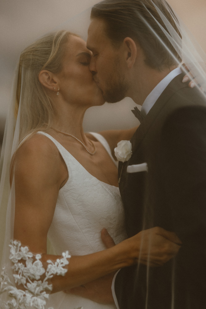 Bride and groom at Montville under the veil kissing with stormy skies in the background