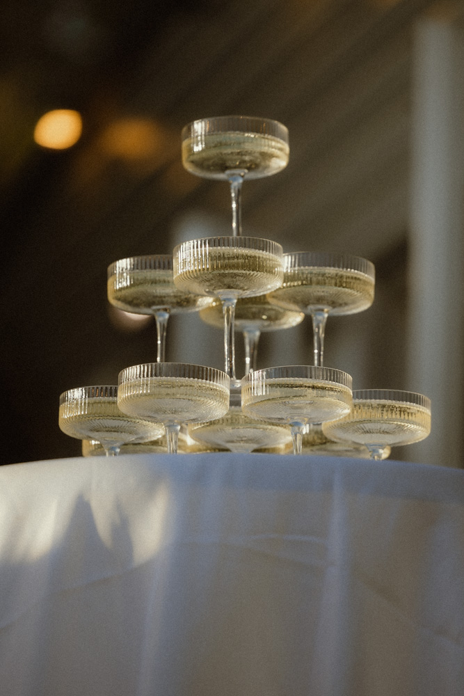 Golden hour light catches champagne tower